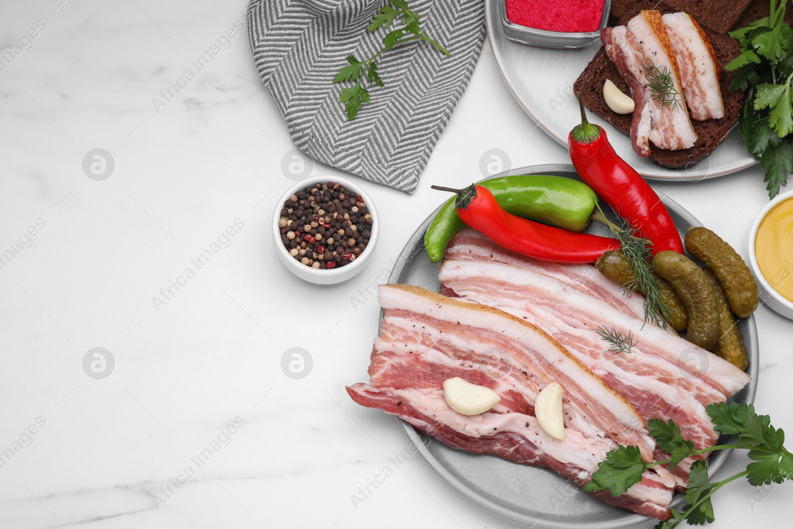 Photo of Tasty pork fatback served on white marble table, flat lay. Space for text