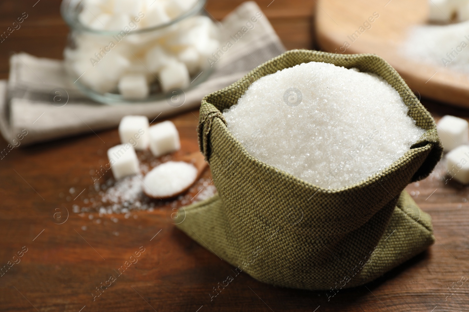 Photo of Granulated sugar in sack on wooden table