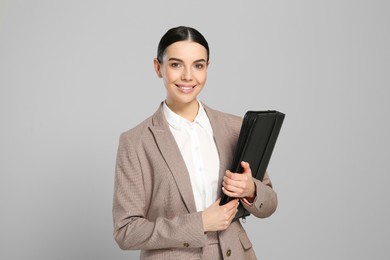 Photo of Beautiful real estate agent with documents on grey background