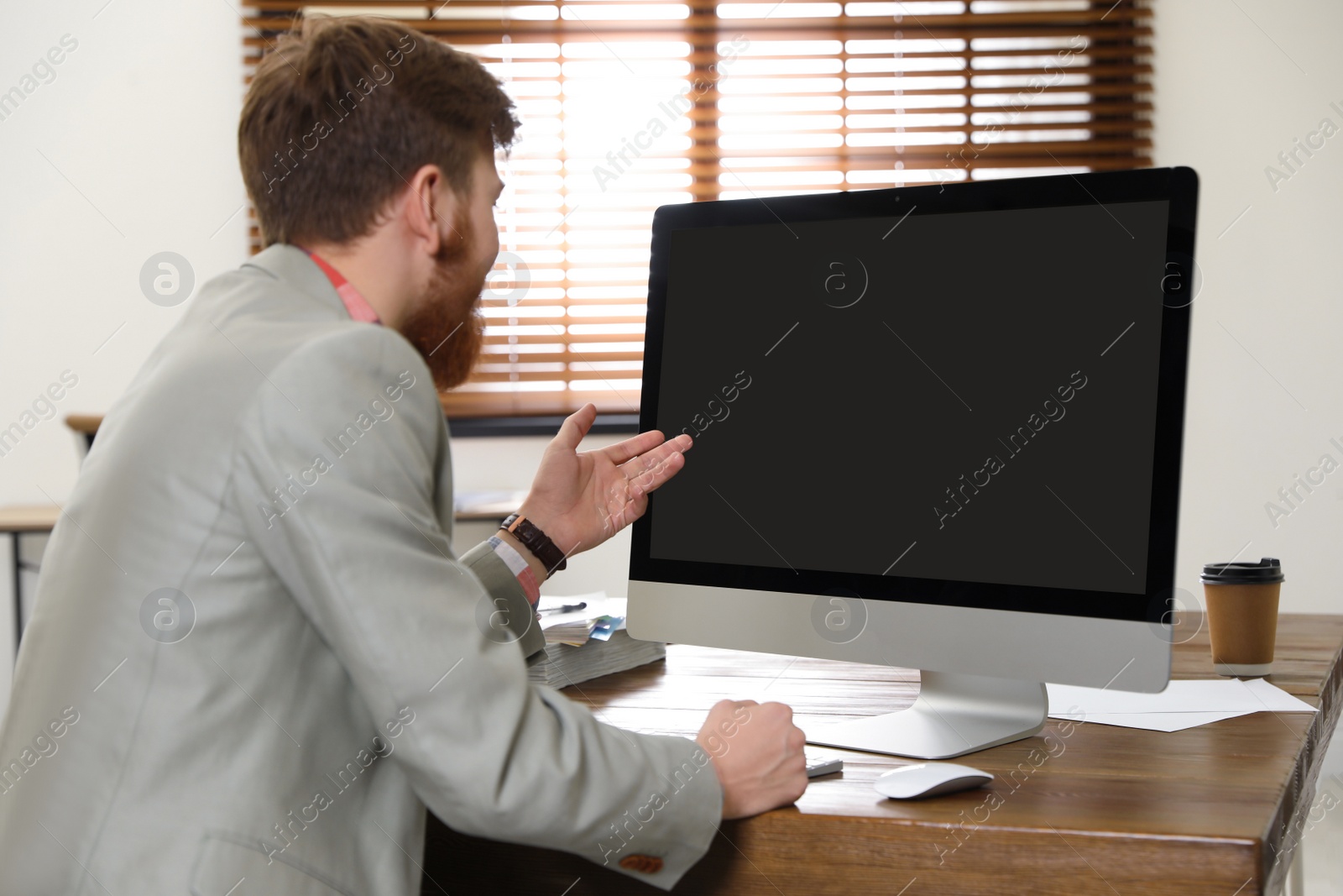 Photo of Man using video chat on computer in home office. Space for text