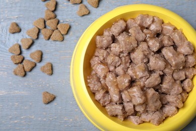 Wet and dry pet food on blue wooden table, flat lay