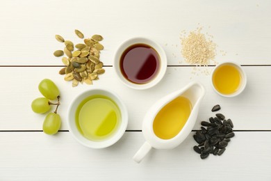 Photo of Vegetable fats. Different cooking oils and ingredients on white wooden table, flat lay