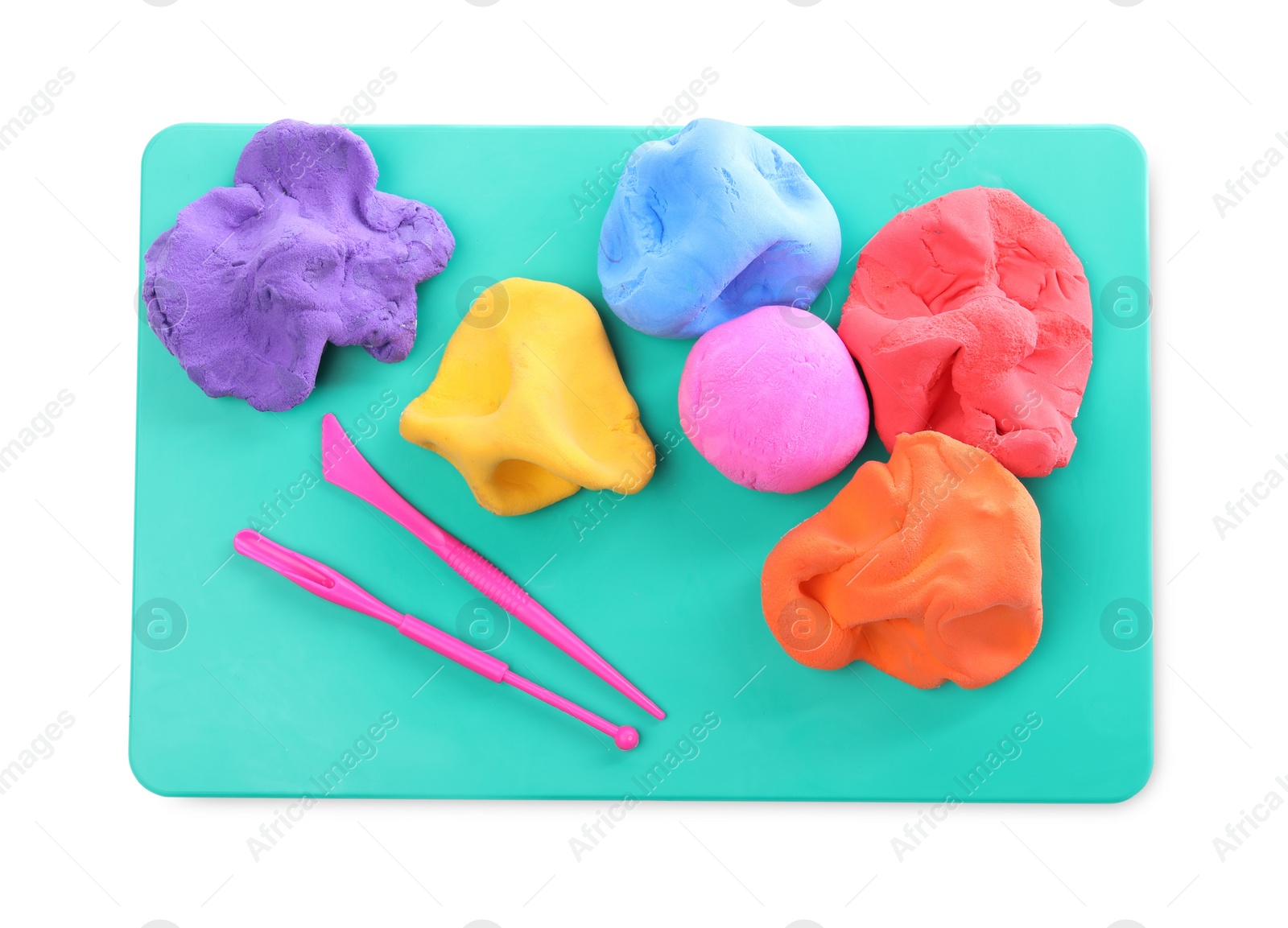 Photo of Board with plasticine and tools on white background, top view