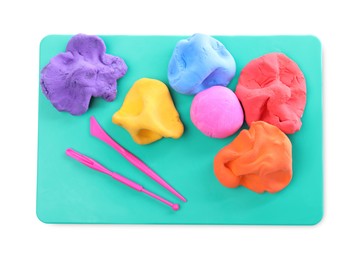 Photo of Board with plasticine and tools on white background, top view