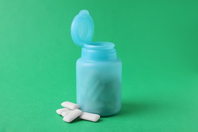 Photo of Jar with chewing gums on green background