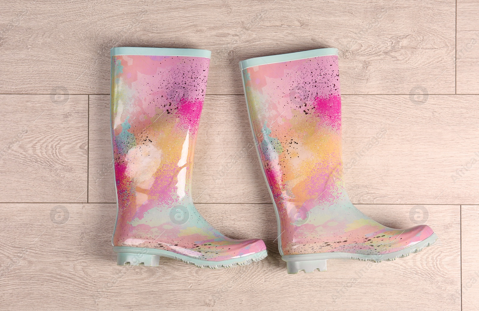 Photo of Pair of gumboots on wooden background, top view. Female shoes