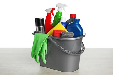 Grey bucket with car care products on wooden table against white background