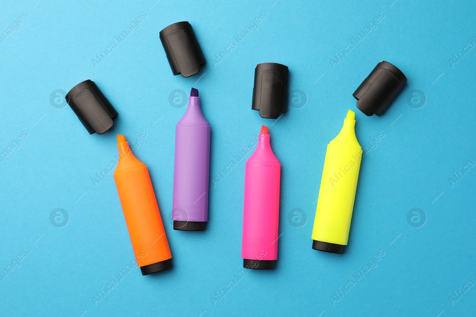Photo of Bright markers on light blue background, flat lay