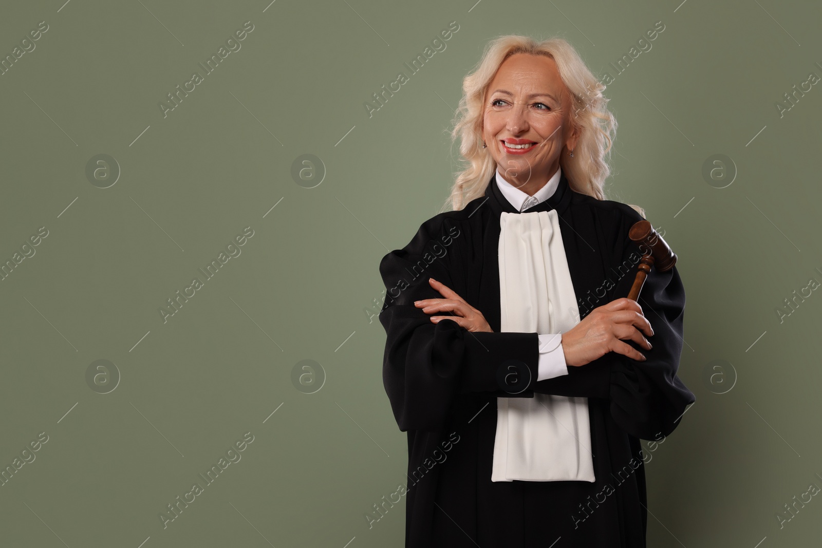 Photo of Senior judge with gavel on green background. Space for text