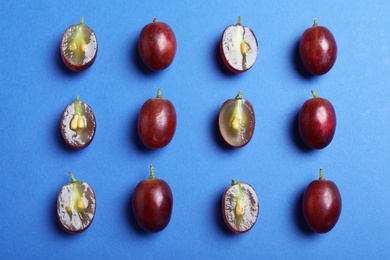 Photo of Flat lay composition with fresh ripe juicy grapes on blue background