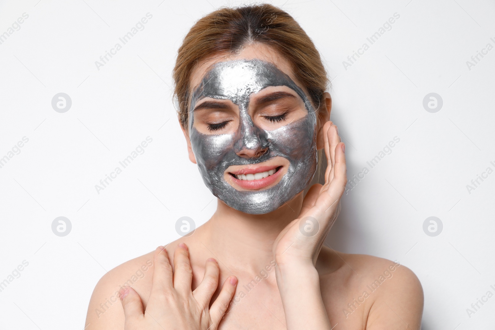 Photo of Beautiful woman with mask on face against light background