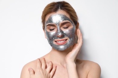 Photo of Beautiful woman with mask on face against light background