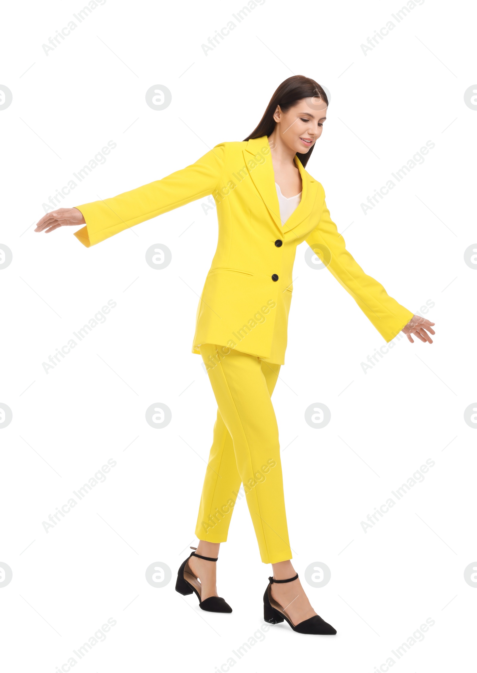 Photo of Beautiful businesswoman in yellow suit walking on white background