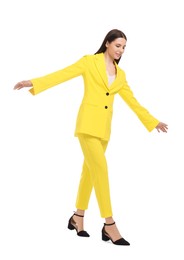 Photo of Beautiful businesswoman in yellow suit walking on white background