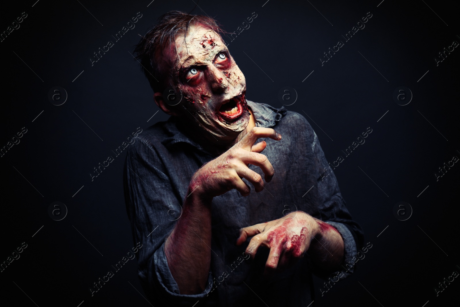 Photo of Scary zombie on dark background. Halloween monster