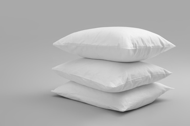 Clean soft bed pillows on grey background