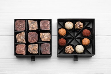 Photo of Boxes of tasty chocolate candies on white wooden table, flat lay