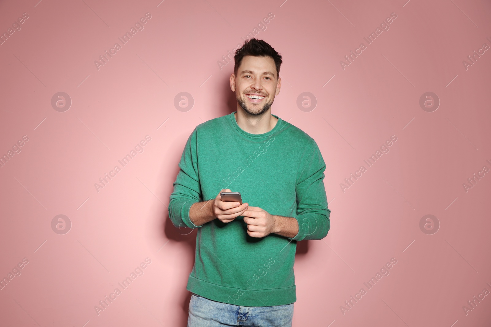 Photo of Handsome man with mobile phone on color background
