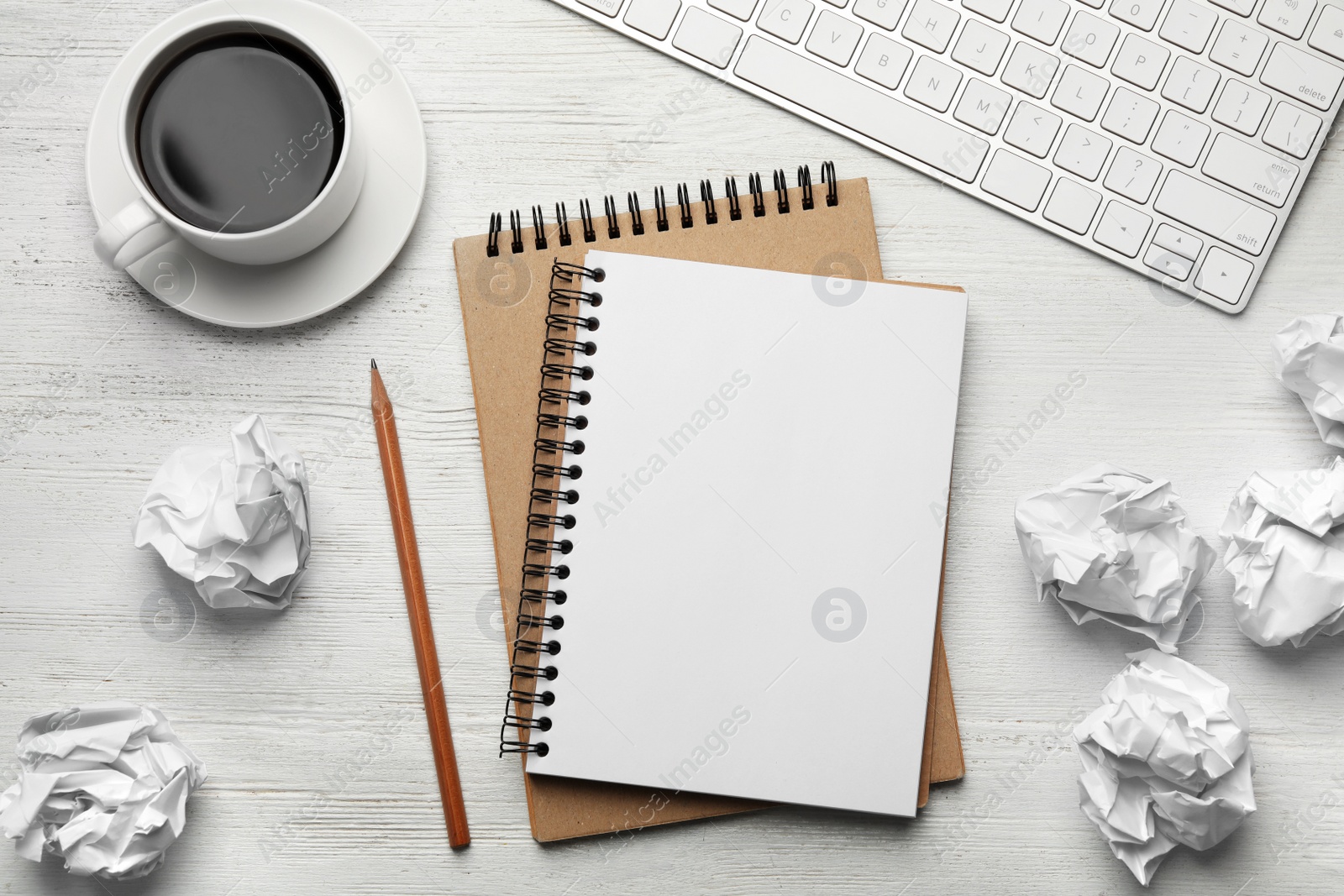 Photo of Flat lay composition with empty notebook and crumpled paper balls on white wooden table. Space for text