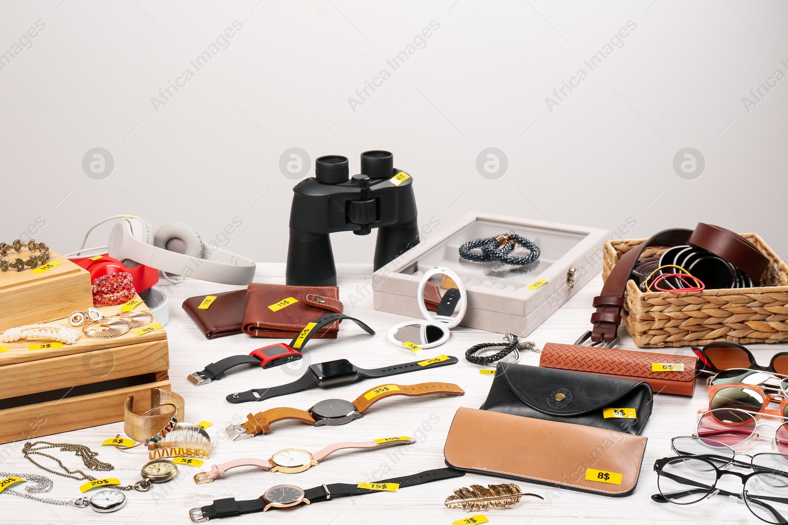 Photo of Many different items on white table indoors. Garage sale