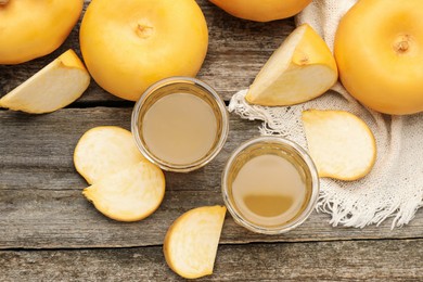 Photo of Glasses of freshly made turnip juice on wooden table, flat lay