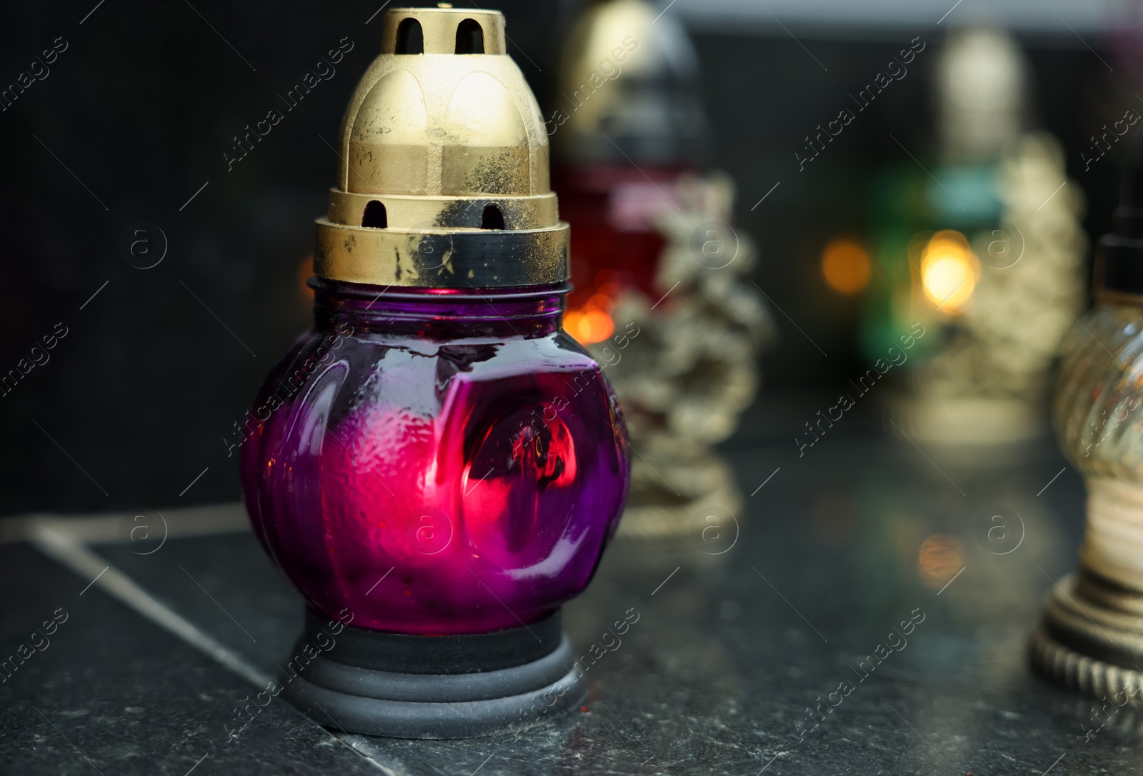 Photo of Grave lights on granite surface at cemetery, closeup