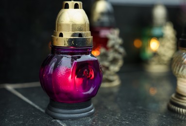 Grave lights on granite surface at cemetery, closeup