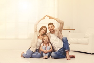 Image of Happy family forming house roof with their hands at home. Insurance concept