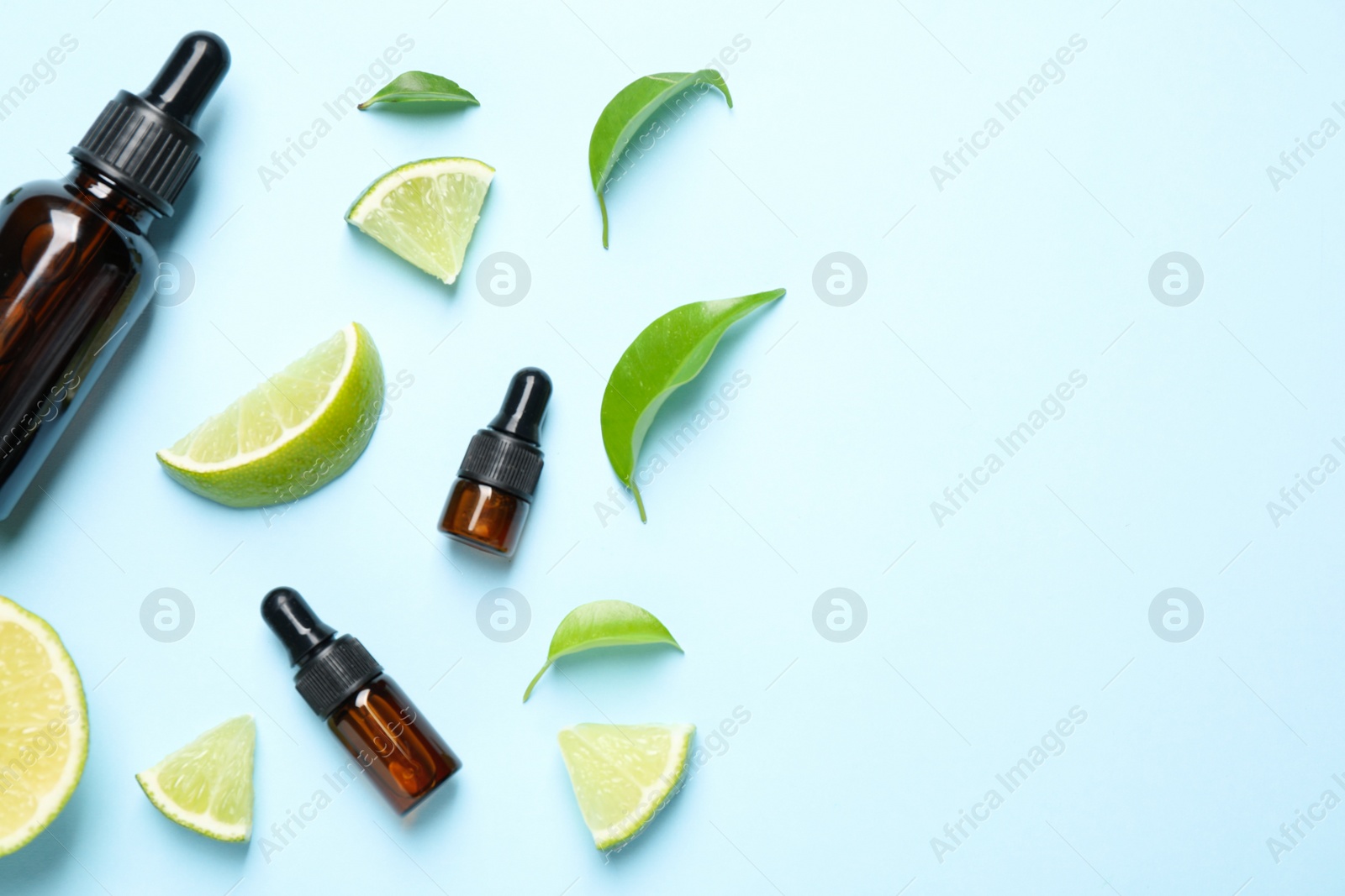 Photo of Flat lay composition with lime essential oil on light blue background. Space for text