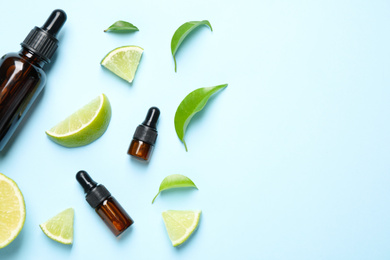 Photo of Flat lay composition with lime essential oil on light blue background. Space for text