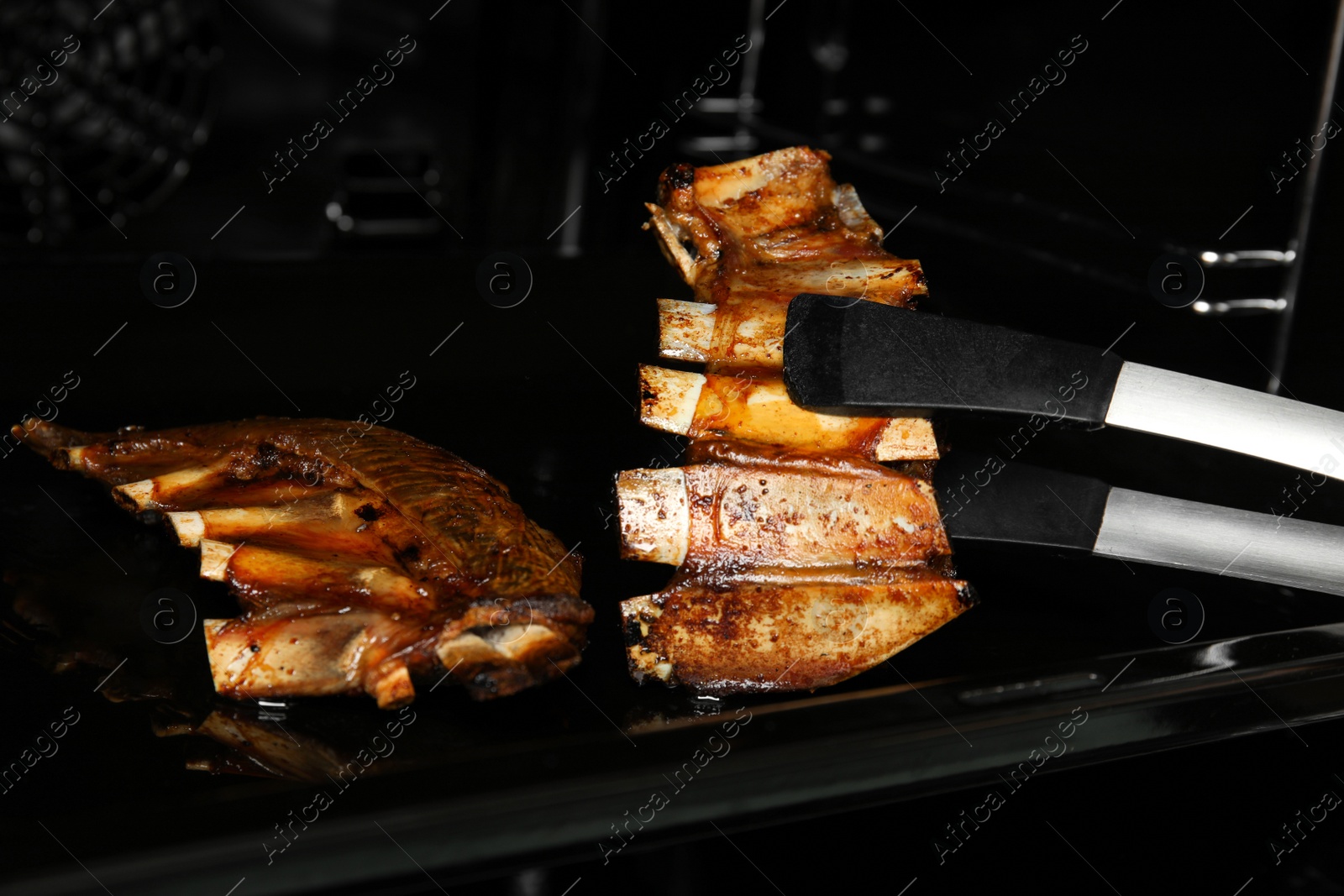 Photo of Delicious roasted ribs in oven. Yummy meat