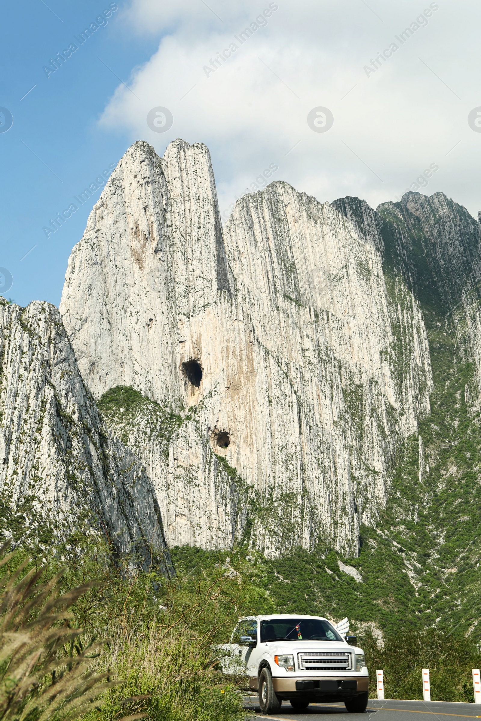 Photo of Picturesque view of big mountains and trees near white car