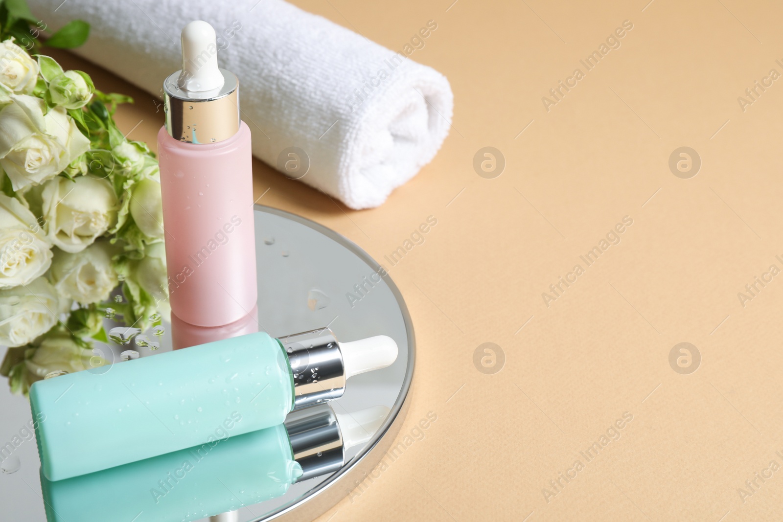 Photo of Composition with bottles of cosmetic products on beige table. Space for text