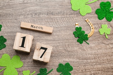 Photo of Flat lay composition with block calendar on grey wooden table. Saint Patrick's Day celebration