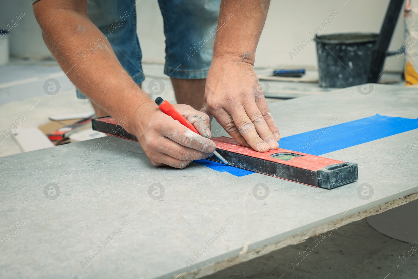 Photo of Worker making socket hole in tile indoors, closeup