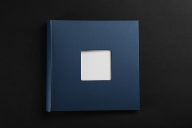 Photo of One photo album on black background, top view