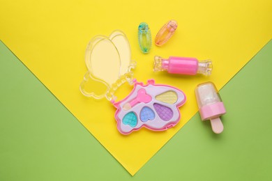 Photo of Decorative cosmetics for kids. Eye shadow palette, lip glosses and hairpins on color background, flat lay