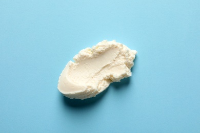 Photo of Smear of tasty cream cheese on color background, top view