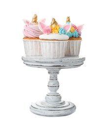 Dessert stand with cute sweet unicorn cupcakes on white background