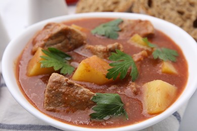 Photo of Delicious goulash in bowl on table, closeup