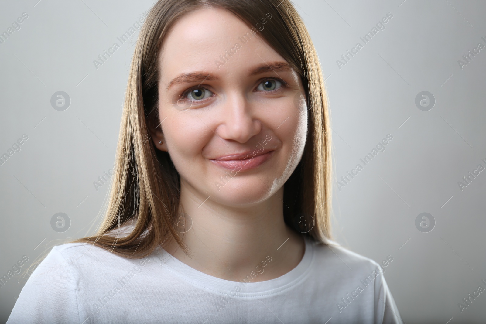 Photo of Portrait of beautiful happy woman on light grey background