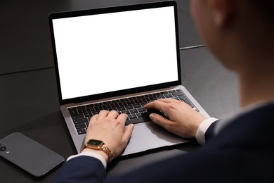 Woman working with laptop at black desk, closeup