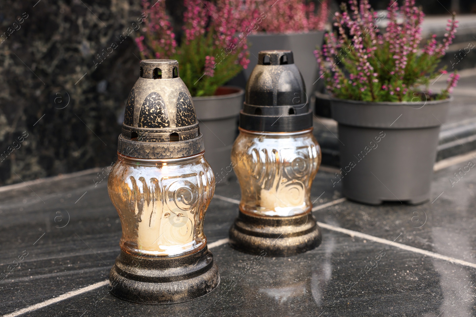 Photo of Grave lanterns on black tiled surface at cemetery