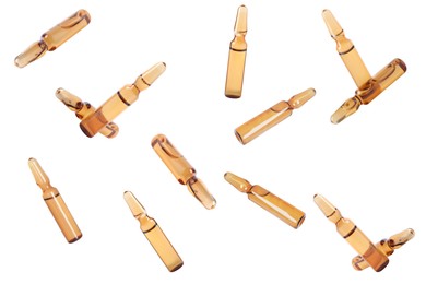 Image of Many glass ampoules with pharmaceutical products falling on white background