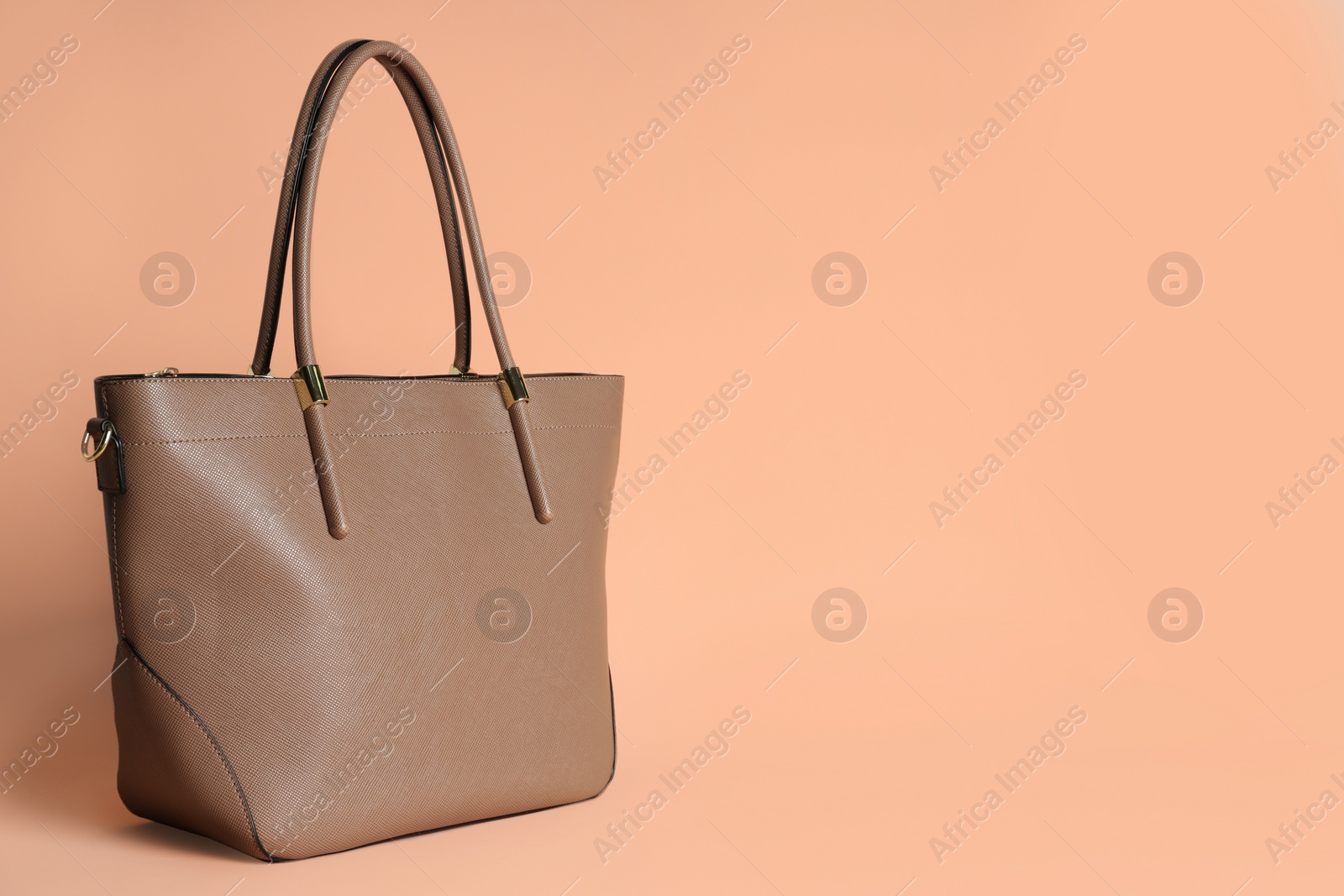 Photo of Stylish woman's bag on pale pink background. Space for text