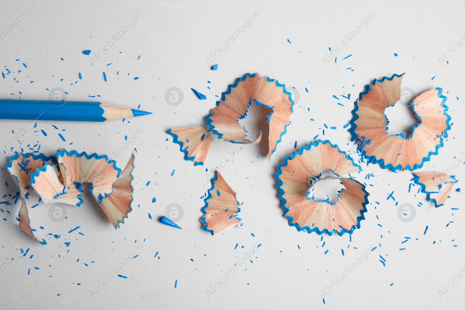 Photo of Color pencil and shavings on grey background, flat lay