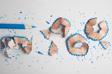 Photo of Color pencil and shavings on grey background, flat lay