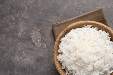 Bowl of tasty cooked rice on grey background, top view. Space for text