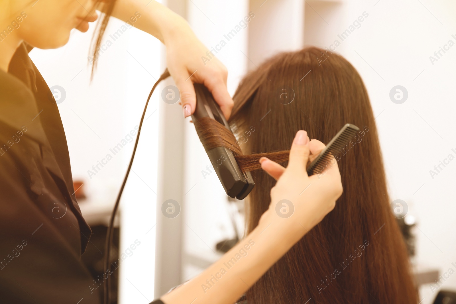 Image of Professional female hairdresser working with client in salon