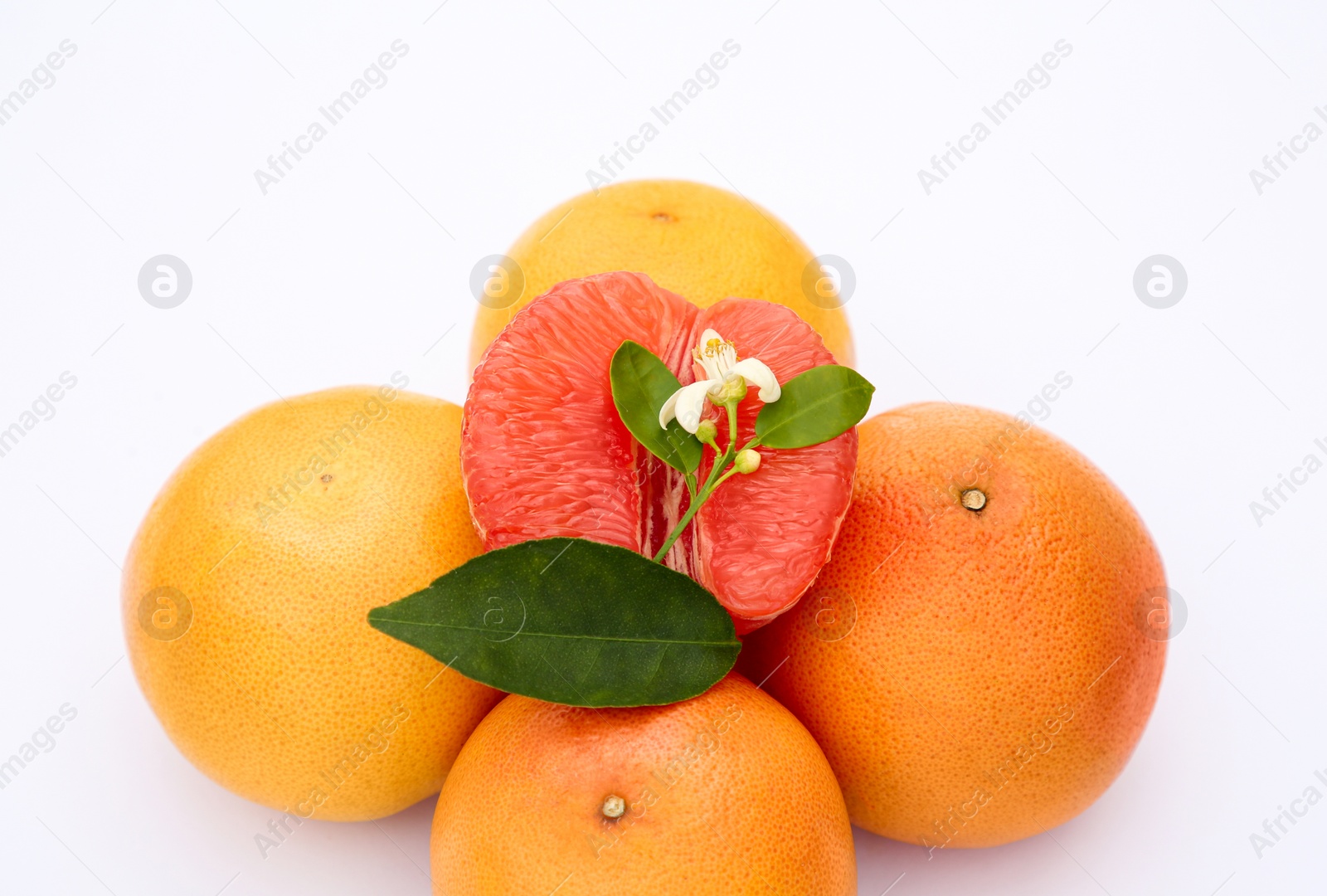 Photo of Fresh grapefruits and green leaves on white background